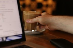 Een kantoorbediende met een kopje koffie.