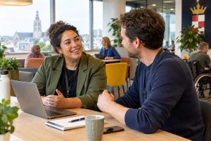 Professional in het sociaal domein aan het werk bij een gemeente in Breda, in gesprek met een collega.