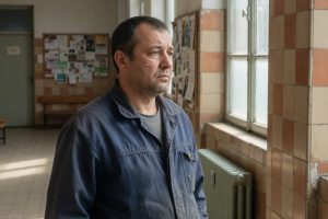 Man wacht in hal van gemeentegebouw onder zacht daglicht