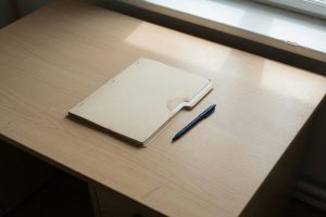 Gesloten dossier en pen op een bureau